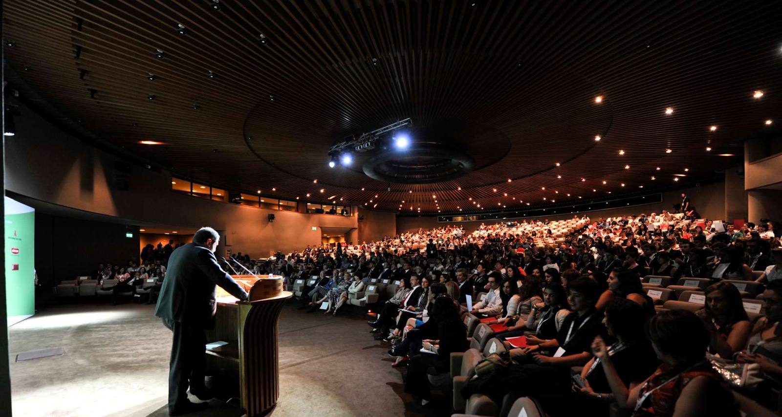 Guido Silipo parla da un leggio davanti a un auditorium gremito